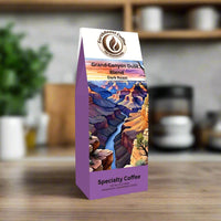 Front view of EarthRoast Coffee's Grand Canyon Dusk Blend, a dark roast specialty coffee. Features a vibrant illustration of the Grand Canyon at sunset, emphasizing the bold flavors and sustainably sourced, organic quality of this premium coffee.