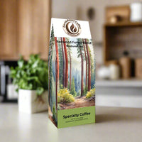 Front view of EarthRoast Coffee's Redwood Forest Blend Medium Roast bag. Features a serene watercolor illustration of a redwood forest path, emphasizing the organic, sustainably sourced specialty coffee and its connection to nature.